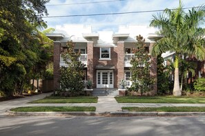 A multi-story building with a symmetrical facade, brickwork, and a central entrance with steps.
