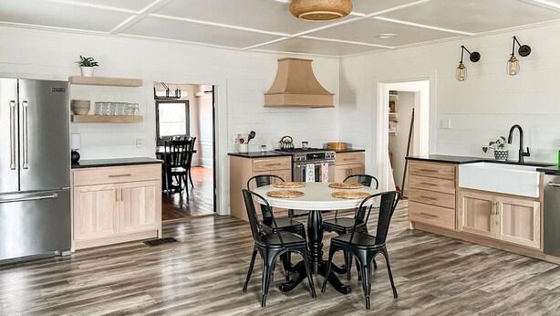 Une cuisine moderne dotée d’un îlot central, de meubles en bois et d’un réfrigérateur en acier inoxydable.