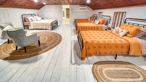 Une chambre confortable située sous les toits, avec deux lits, une chaise et une grande fenêtre.