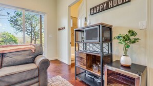 A living room with a gray sofa, a wooden coffee table, a bookshelf, and a potted plant.