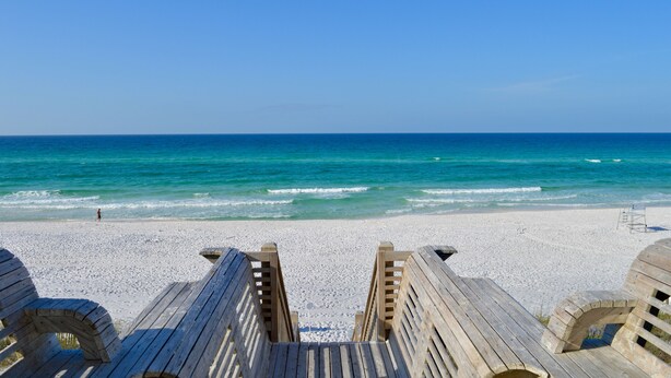 A beach with wooden boardwalks leading to the shore, a clear blue sky, and the ocean. - Seaside, FL, Steps to Pool! Walk to Beach, Sleeps 6 + 2 Adult Bikes! (Santa Rosa Beach Fl)
