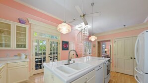 A kitchen with a white countertop, double sink, and a ceiling fan. - Seaside, FL, Steps to Pool! Walk to Beach, Sleeps 6 + 2 Adult Bikes! (Santa Rosa Beach Fl)