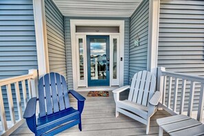 A porch with two Adirondack chairs, a door with a glass panel, and a small rug. - Tidal Walk * New 5BR Bethany Beach House (Millville)