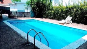 A rectangular swimming pool with a clear blue water, surrounded by a paved area and a white fence. - Magnifique Appartement Meublé Avec Piscine à Pointe Noire (Pointe-Noire)