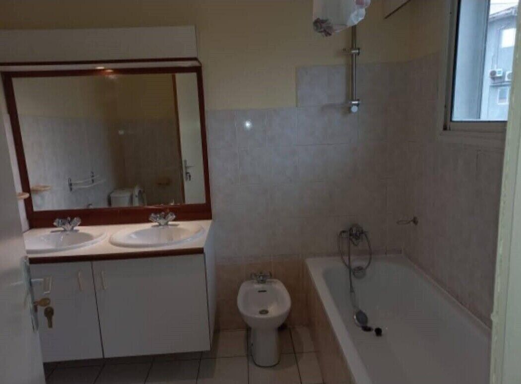 A bathroom with two sinks, a bidet, and a bathtub.