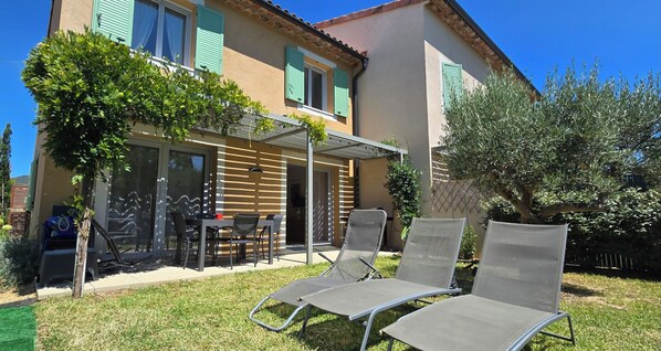 A house with a patio, outdoor seating, and a garden. - New house with all comforts in Grimaud (Grimaud)