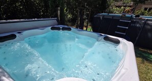 A hot tub with a clear blue water surface, surrounded by a wooden deck and a metal fence. - New house with all comforts in Grimaud (Grimaud)