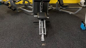 A gym with various exercise equipment, including a chest press machine, a bench press, and a squat rack. - Darwin City Hotel Suite with Sea View & Balcony  (Darwin City)