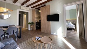 Ein modernes Wohnzimmer mit Essbereich, einer Küche und einem Schlafzimmer.