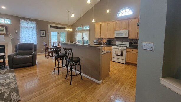 A spacious kitchen with wooden cabinets, a central island, and a dining area with chairs.