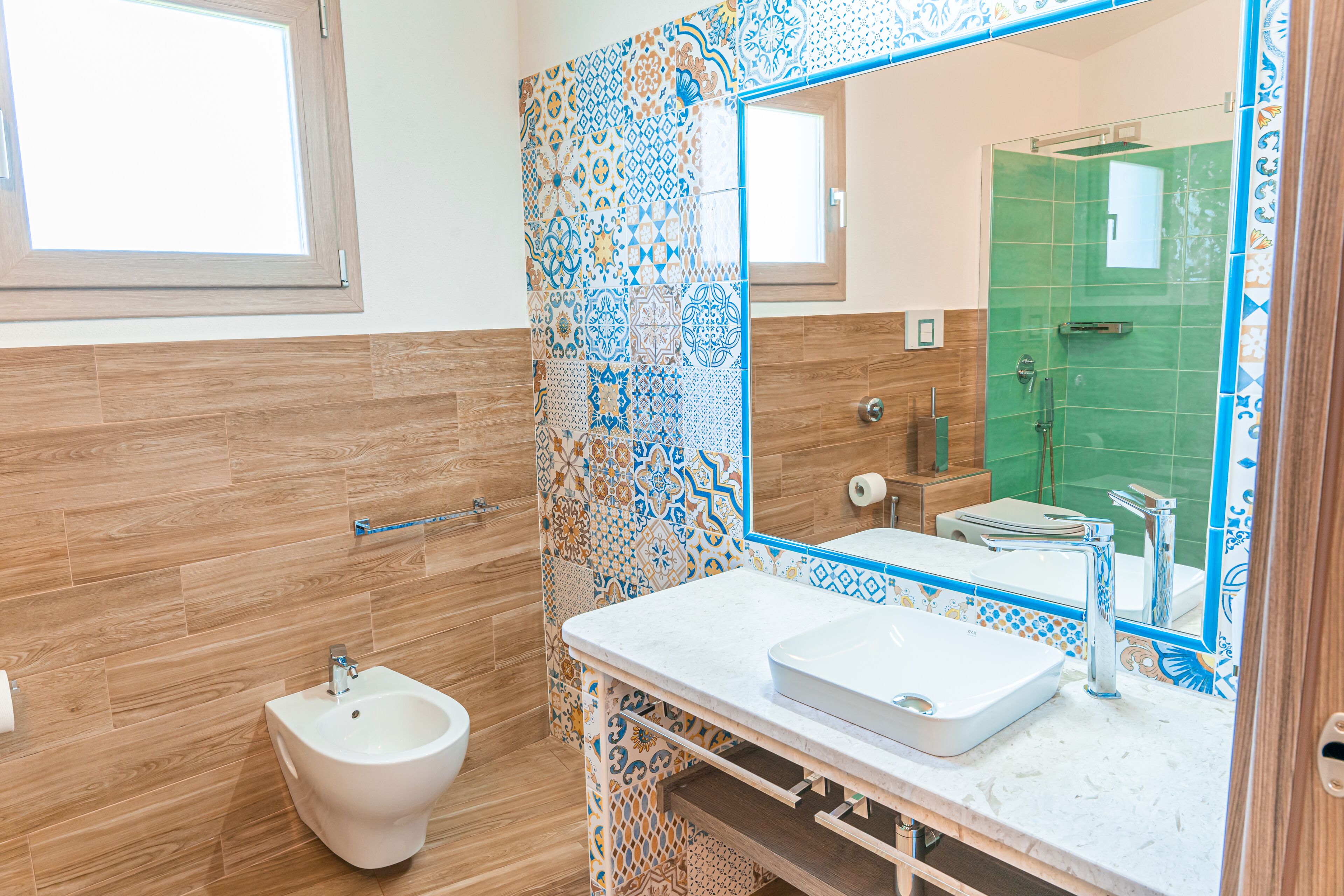 A bathroom with a bidet, a sink, and a mirror.
