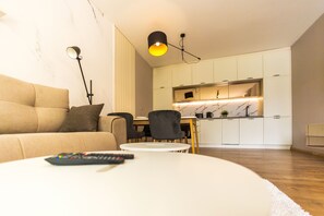 Un salon moderne avec un canapé, une table basse et une télécommande.
