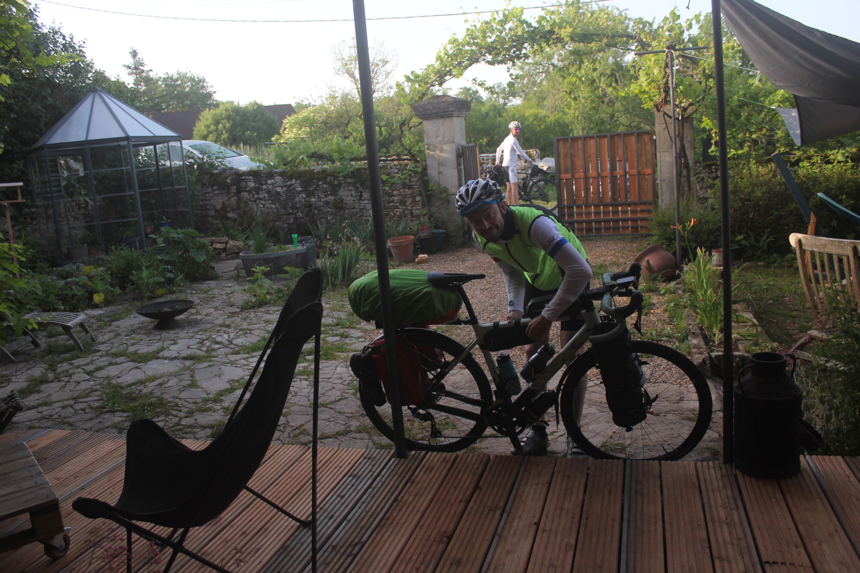 Una terraza de madera con una bicicleta y una persona ajustándola.