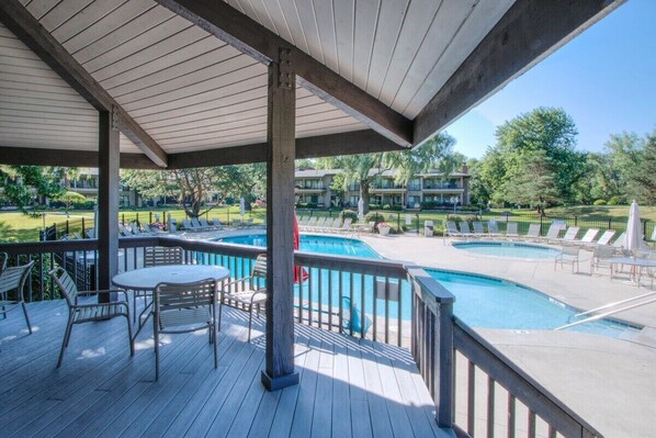 Relax by the pool surrounded by lounge chairs and umbrellas.