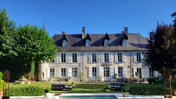 A large stone building with multiple windows and a swimming pool in the foreground. - Logis des Tourelles (Cognac)