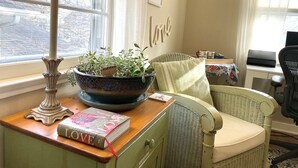 A cozy room with a wicker chair, a wooden table with a book and a potted plant, a lamp, and a desk with a printer. - Cozy apartment getaway in Holland (Holland)