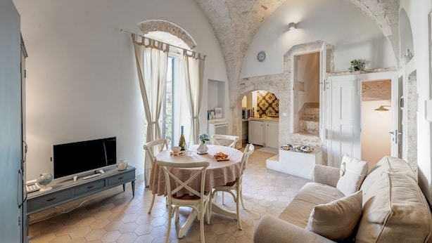 A cozy living room with a TV, dining table, and comfortable seating. - CA'milla Suite Home (Ostuni)