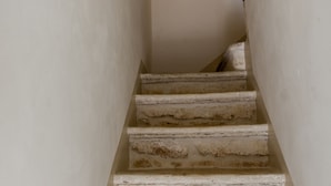 A narrow staircase with white walls and a light fixture at the top. - CA'milla Suite Home (Ostuni)