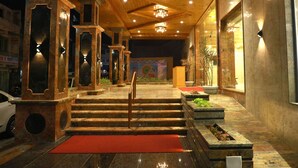 A hotel lobby with a wooden ceiling, a staircase, and a red carpet. - Hotel The Grand Ladhukara (Dwarka)