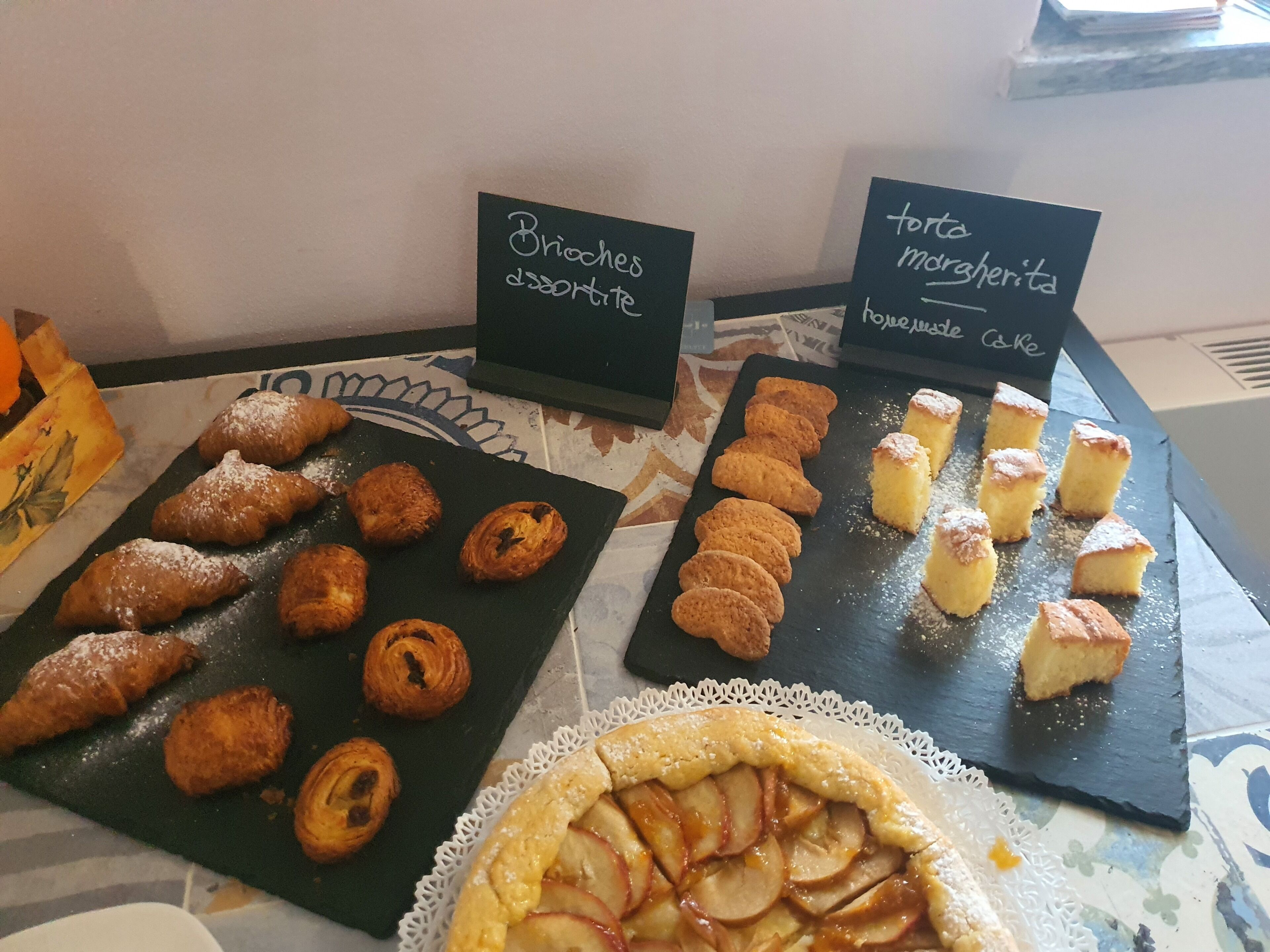 Una mesa de bufé con diversos pasteles y postres, incluyendo brioche y torta mdrsherta.
