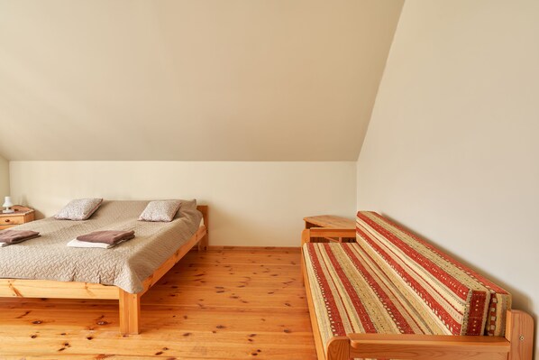 Ein Schlafzimmer mit einem Holzbett, einer Bank und einem kleinen Tisch.