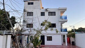 Un edificio moderno de varios pisos con techo plano, varias ventanas y un balcón.