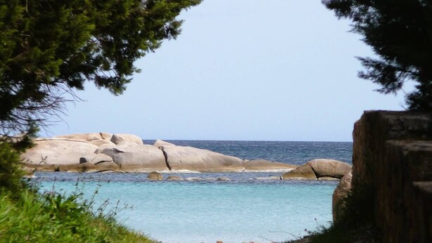 A coastal landscape with large boulders, clear turquoise water, and a view of the ocean. - Appartement Lena. 6 pers,  piscine, 500 m plage (SAINTE LUCIE DE PORTO VECCHIO)