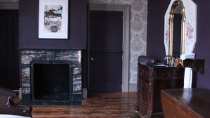 A room with a fireplace, a mirror, and a bed. - The Wedding Cake House (Providence)