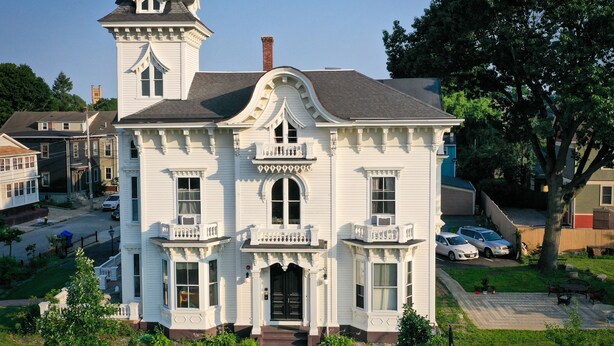 A large, white, two-story building with a prominent tower and a balcony. - The Wedding Cake House (Providence)