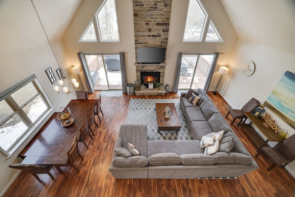 A spacious loft with a large dining area, a fireplace, a sofa, and a television.