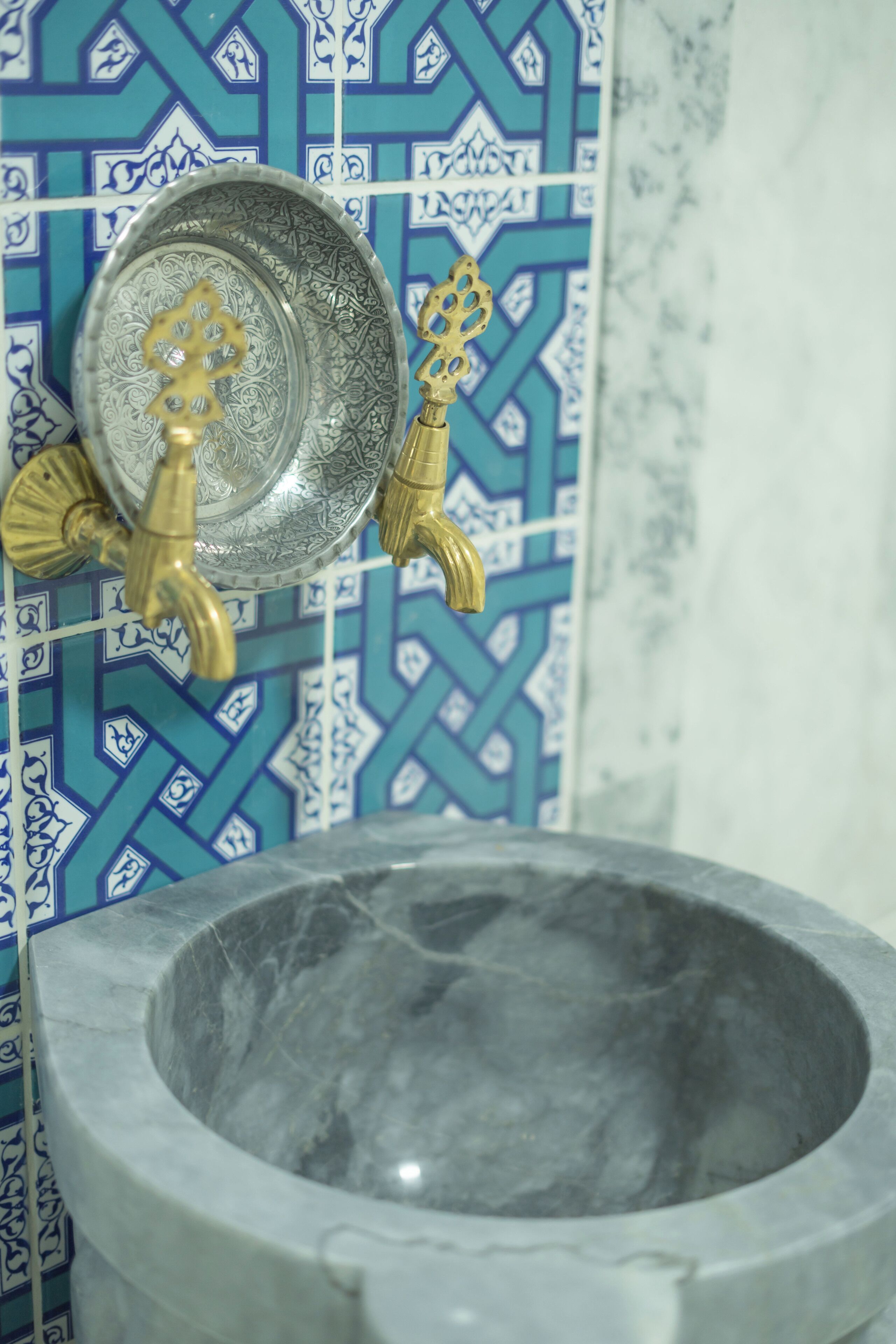 A bathroom with a stone basin and a decorative faucet.