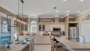 A spacious kitchen with a large island, modern appliances, and a view of the backyard.