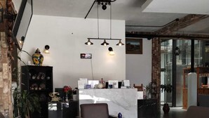 Un vestíbulo moderno con mostrador de recepción, zona de estar y un ventanal grande.