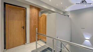 A modern staircase with metal railings, wooden doors, and a ceiling with recessed lighting. - Grand Museum Guest House pyramids view (Giza)