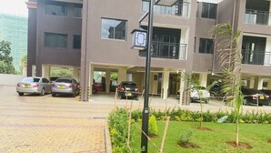 Un edificio residencial de varios pisos con un área de estacionamiento.