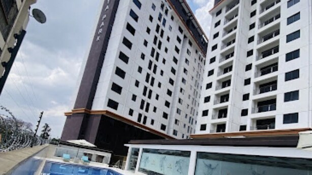 Un hotel moderno con piscina, edificios altos y cielo despejado.