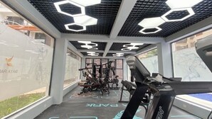Un gimnasio con suelo de patrón hexagonal, cintas de correr y máquinas de pesas.