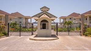 A gated entrance with a central archway leading to a row of townhouses. - Imperial Topaz At Richmond (St. Ann's Bay)