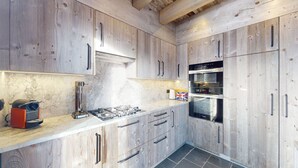 Una cocina moderna con armarios de madera, estufa a gas y horno empotrado.