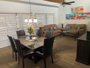 A dining area with a glass table, chairs, and a chandelier. There is a sofa and a coffee table in the living area. - Resort living without the resort price! Quiet & pet friendly, walking trails (Haines City)