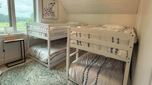 Ein Schlafzimmer mit Etagenbetten, einem Fenster mit Blick und einem Bild an der Wand.