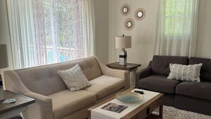 Una sala de estar con dos sofás, una mesa de centro y una lámpara.