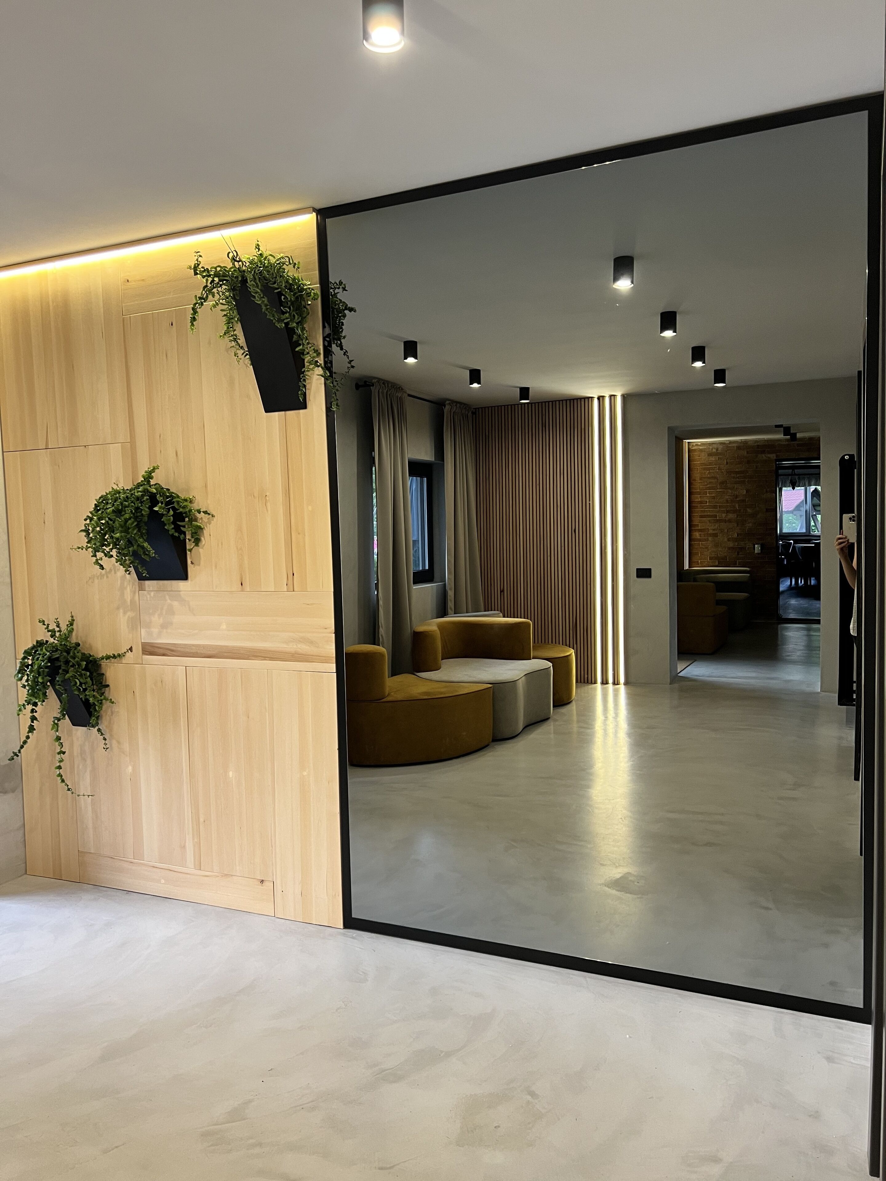 A modern interior with a wooden partition, seating area, and potted plants.