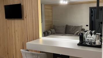 Una cocina moderna con una isla integrada, un televisor de pantalla plana montado en una pared de madera y una cafetera sobre la isla.