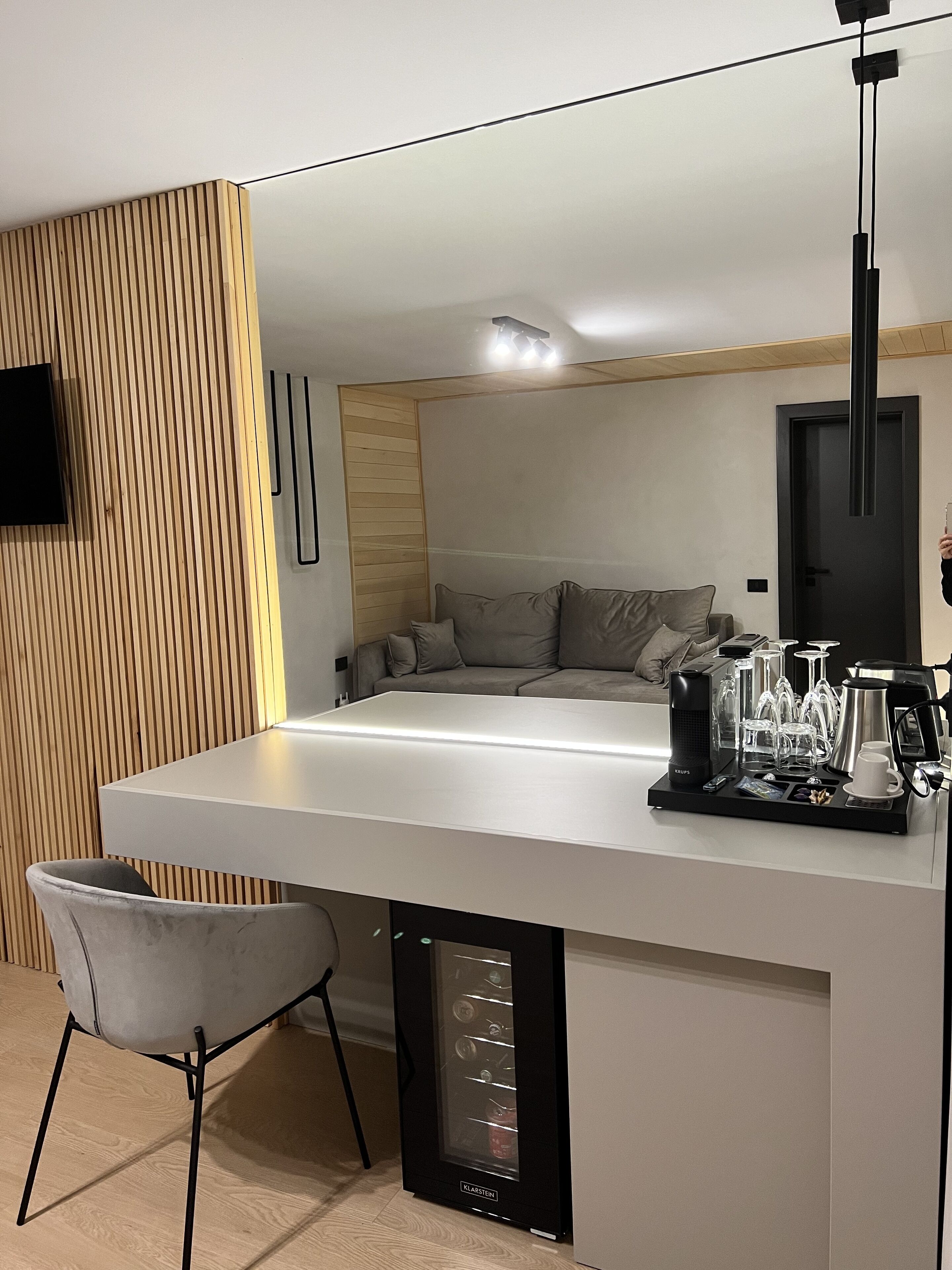 A modern kitchen with a central island, a built-in refrigerator, and a seating area with a sofa and chairs.