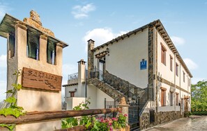 Un bâtiment traditionnel doté d’un escalier en pierre et d’une enseigne en bois sur laquelle on peut lire « BARBACO ».