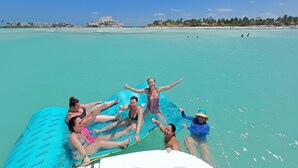 A group of people on a blue inflatable raft in clear turquoise water. - Together to Cancún  (Cancun)