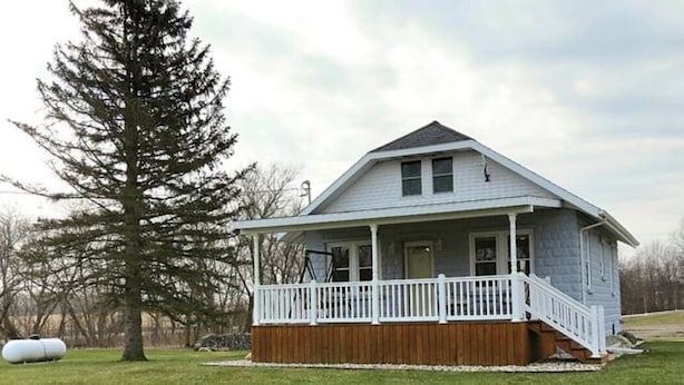 A single-story house with a porch, a wooden deck, and a large tree in the yard. - Countryside Escape - 10 minutes from downtown South Haven! (Bangor)