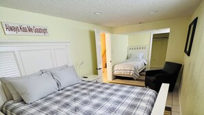 A bedroom with a bed, bedside tables, a chair, a desk, and a wall sign. - Countryside Escape - 10 minutes from downtown South Haven! (Bangor)
