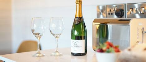 En champagneflaske og to glas på en bordplade.